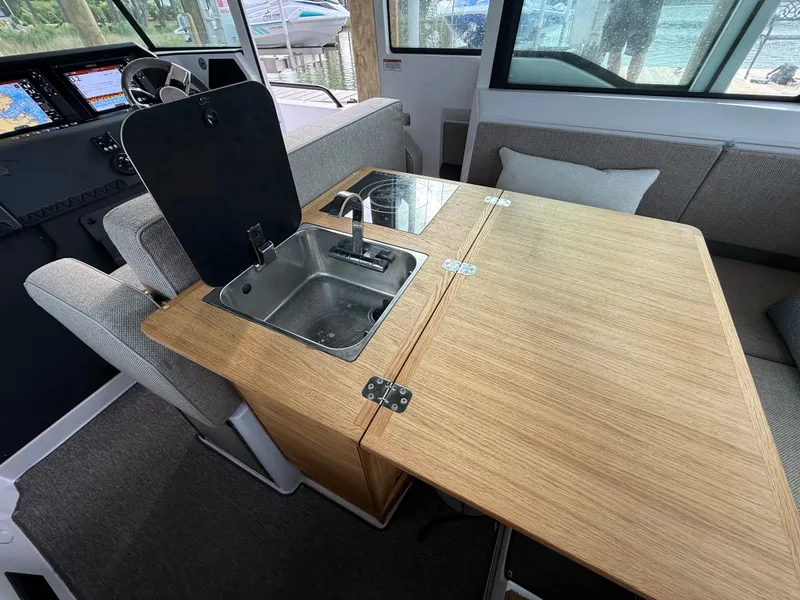 Slide: The Image of Interior of 2025 Axopar 37 XC Cross Cabin with sink and table. - 7