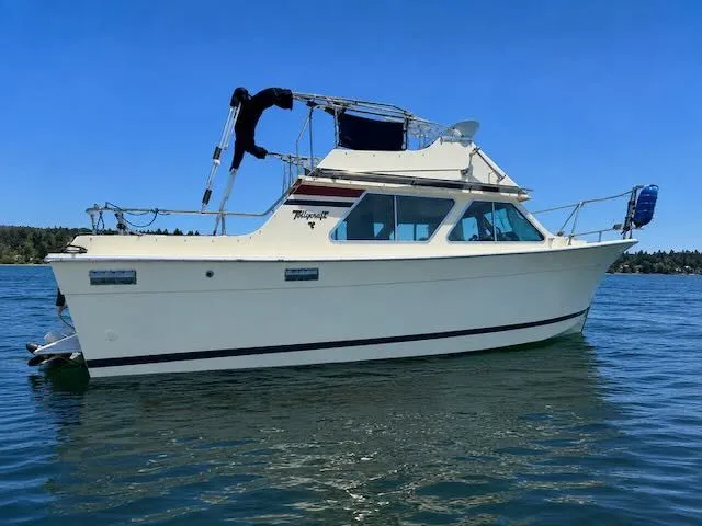 The Image of 1979 Tollycraft 26 boat on calm water under clear sky. - 0