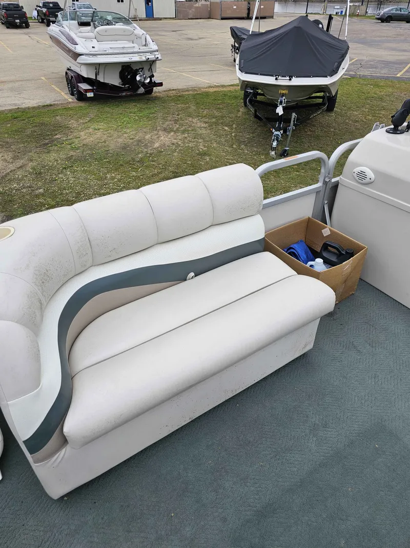 Slide: The Image of Manitou Osprey 24 boat seating, 2004 model, parked outdoors. - 3