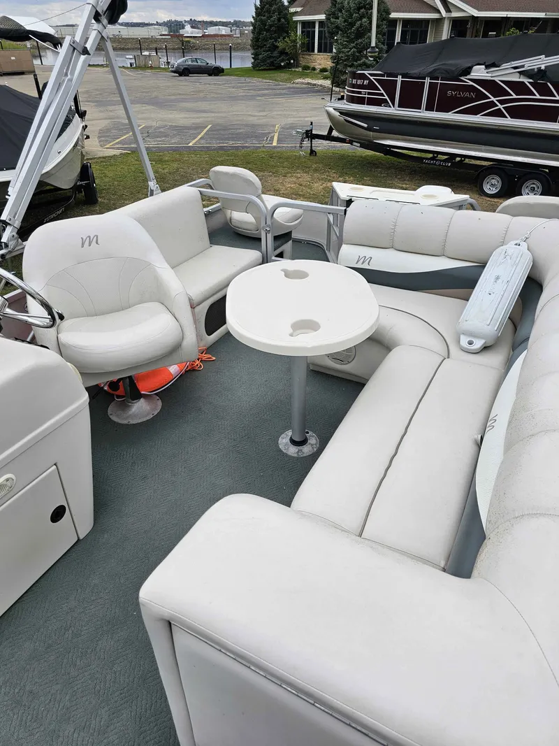 Slide: The Image of Interior of a 2004 Manitou Osprey 24 pontoon boat with seating area. - 7