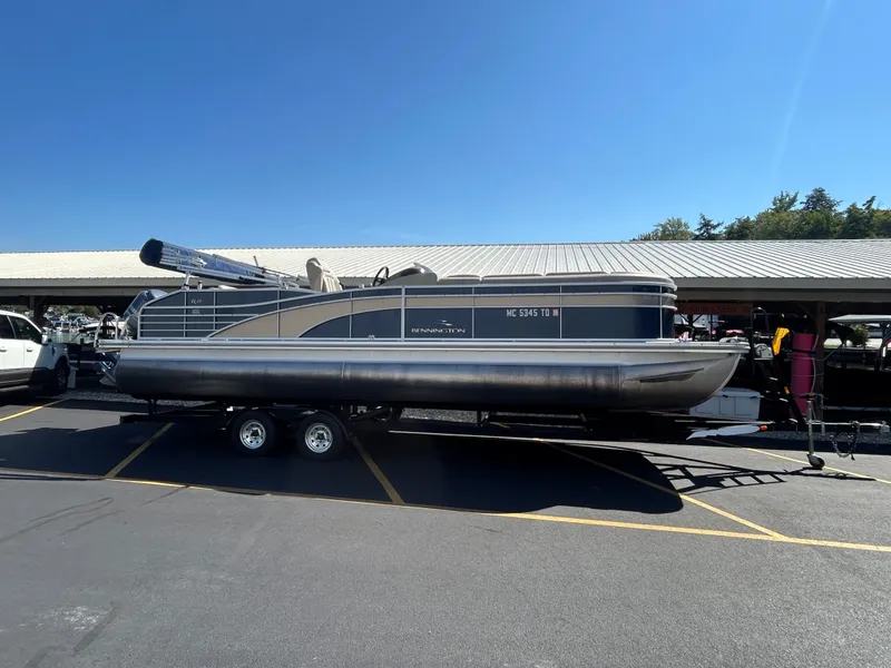The Image of 2014 Bennington R2550 pontoon boat on trailer outdoors. - 1