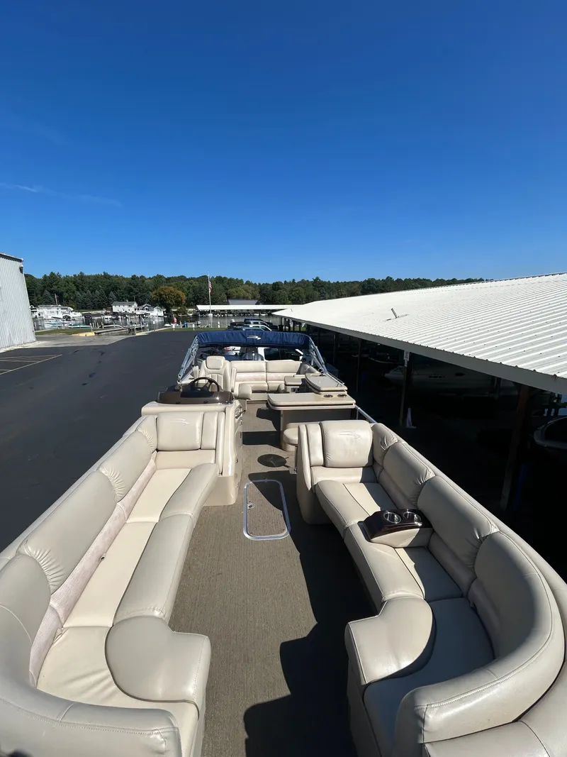 Slide: The Image of 2014 Bennington R2550 pontoon boat with beige leather seating outdoors. - 6