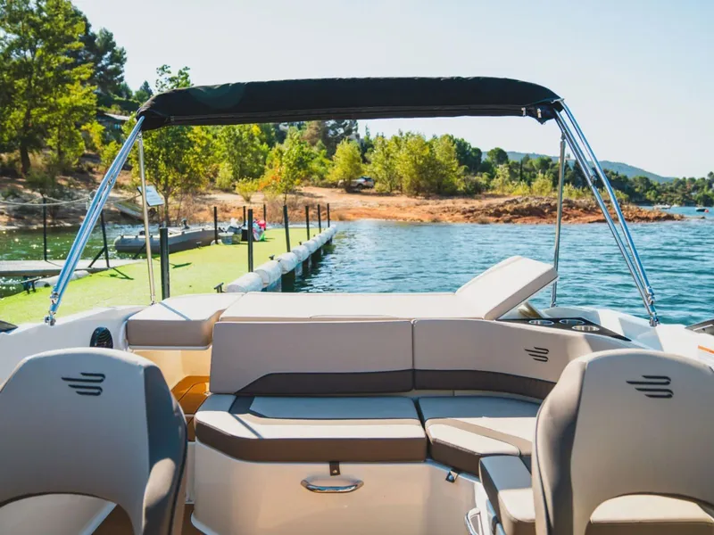 Slide: The Image of Bayliner V20i 2026 boat at lakeside with green landscape. - 3