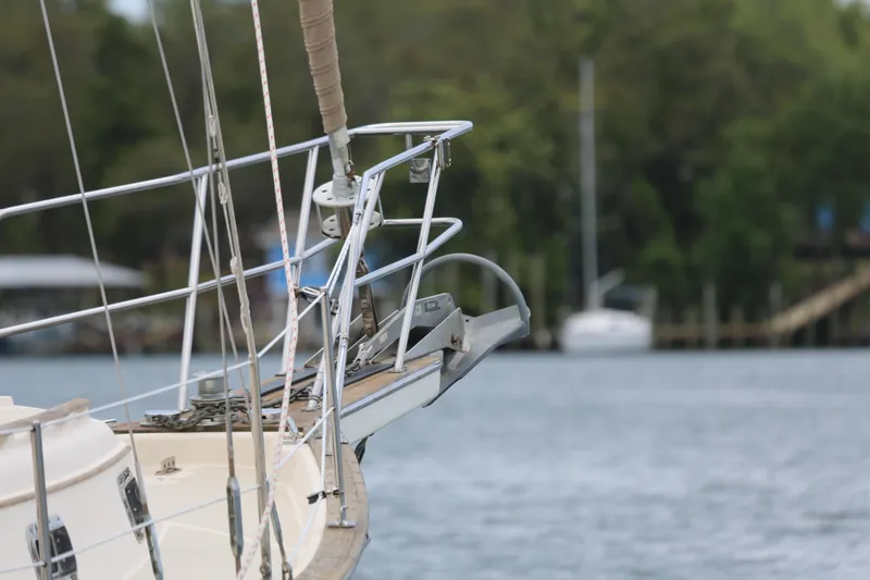 Slide: The Image of Bow of a 1994 Island Packet 35 sailboat with anchor, docked by the water. - 13