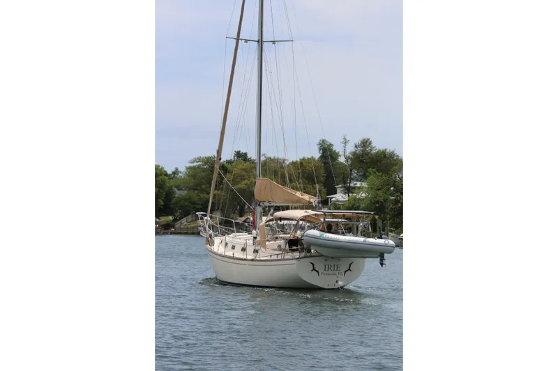 Slide: The Image of Sailboat on water, 1994 Island Packet 35, with trees in the background. - 20