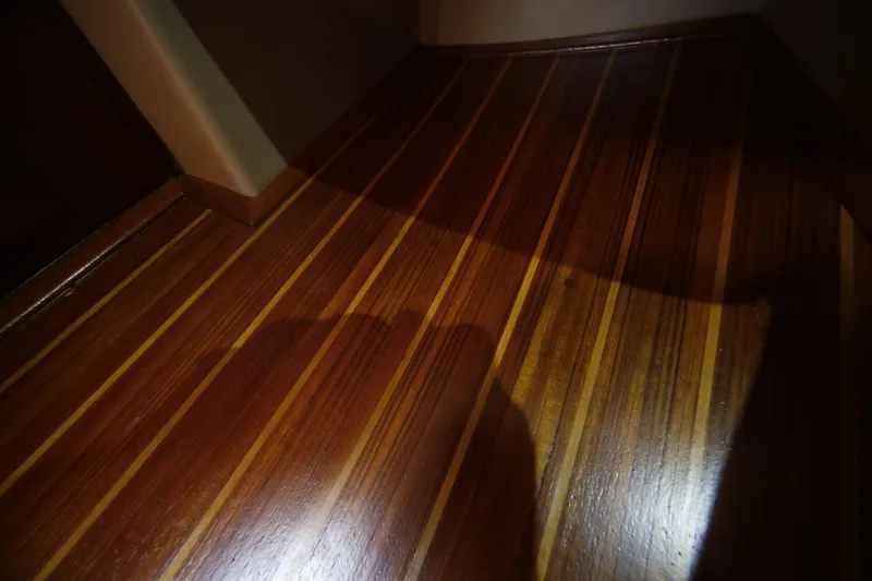 Slide: The Image of Polished wooden floor inside a 1994 Island Packet 35 sailboat. - 26