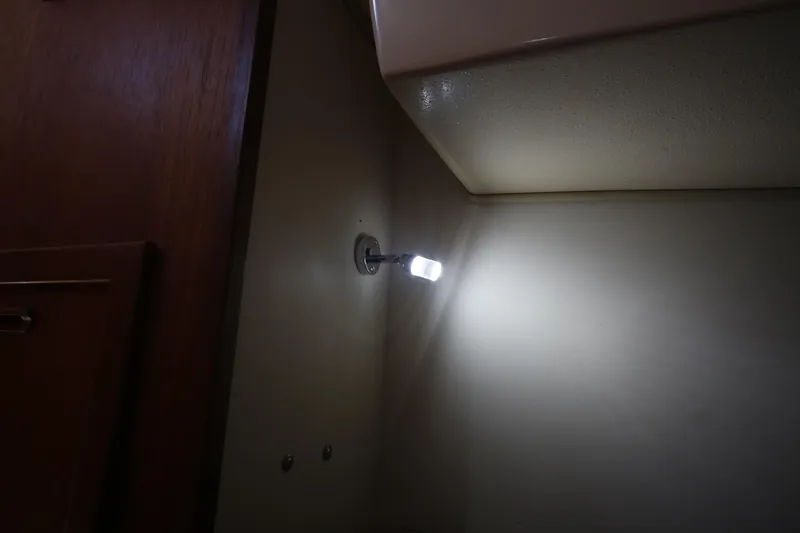 Slide: The Image of Interior cabin light on 1994 Island Packet 35 sailboat, illuminating wooden paneling. - 27