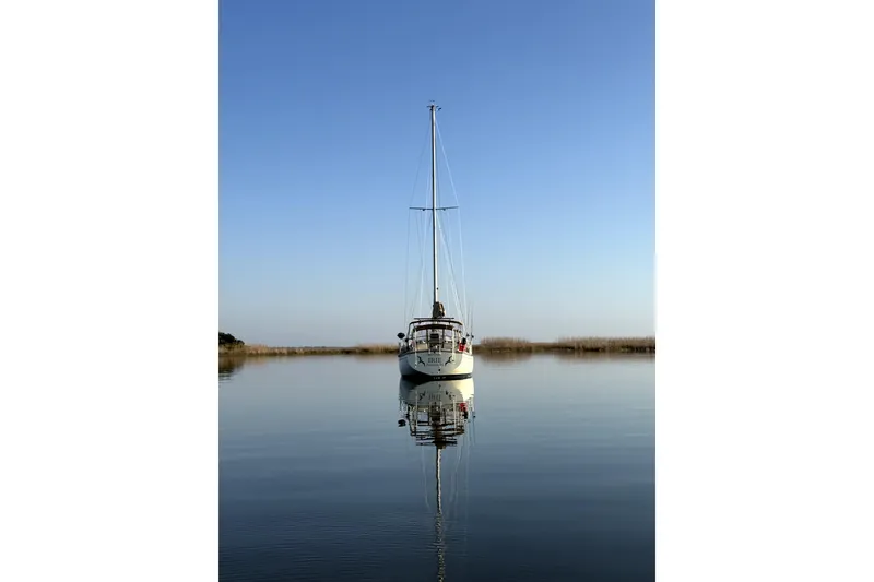 Slide: The Image of Sailboat Island Packet 35, 1994 model, reflected on calm water under clear blue sky. - 49