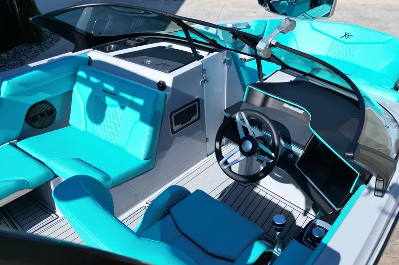 Slide: The Image of 2025 MasterCraft XT24 boat interior with turquoise seating and modern dashboard design. - 12