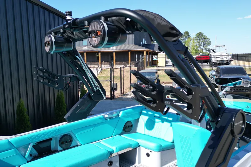 Slide: The Image of 2025 MasterCraft XT24 boat with teal interior and advanced wakeboard tower. - 13