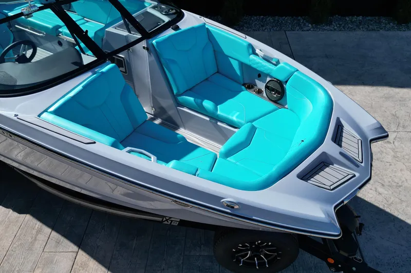 Slide: The Image of 2025 MasterCraft XT24 boat with vibrant turquoise seating and sleek design. - 14