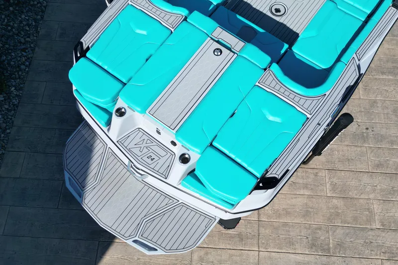 Slide: The Image of 2025 MasterCraft XT24 boat with turquoise seating and sleek design, viewed from above. - 7