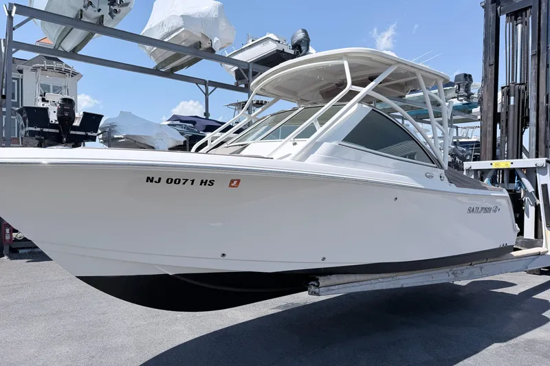 Slide: The Image of 2021 Sailfish 245 DC boat on a lift, showcasing sleek design and modern features. - 21
