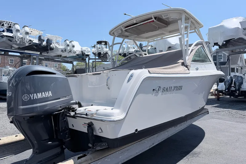 Slide: The Image of 2021 Sailfish 245 DC boat with Yamaha engine, displayed outdoors on a sunny day. - 24