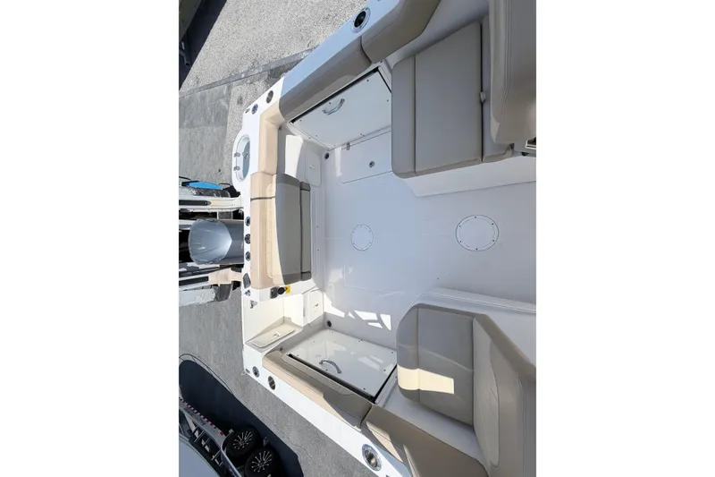 Slide: The Image of 2021 Sailfish 245 DC boat interior with beige seating and spacious deck layout. - 29