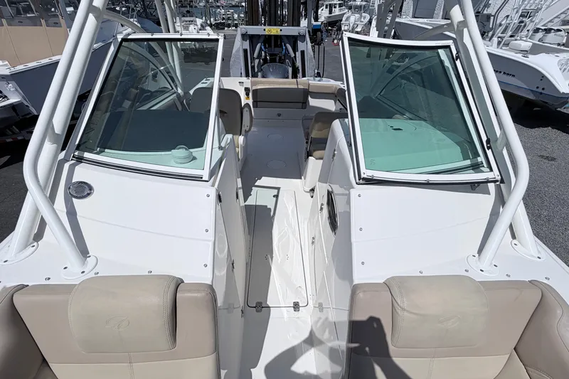 Slide: The Image of 2021 Sailfish 245 DC boat interior with open windshield and beige seating. - 39