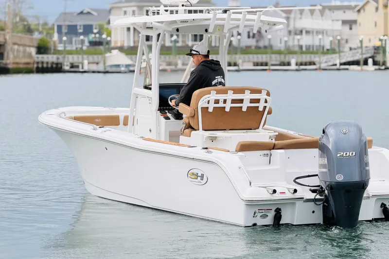 The Image of 2022 Sea Hunt Ultra 234 boat cruising in a marina with Yamaha outboard engine. - 0