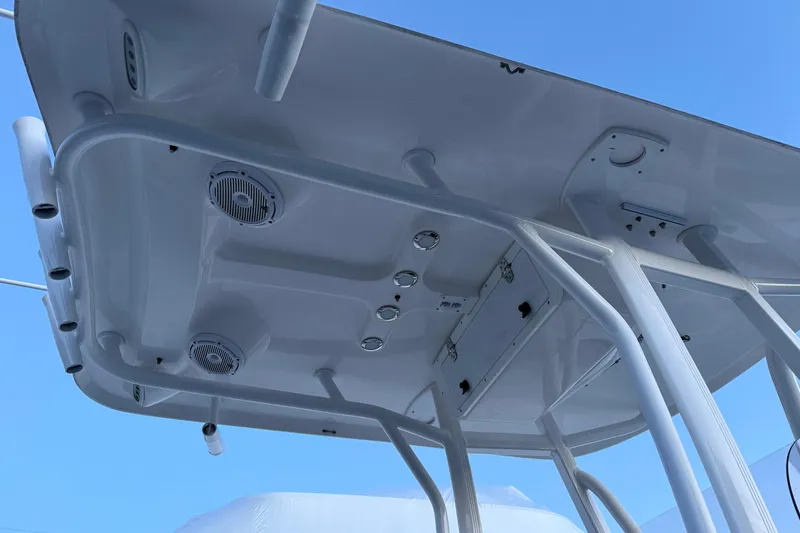 Slide: The Image of 2022 Sea Hunt Ultra 234 boat T-top with speakers and rod holders against blue sky. - 10