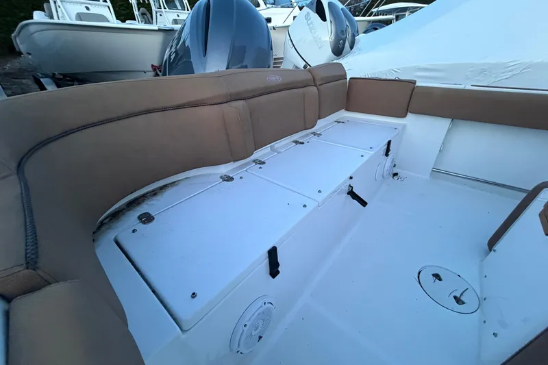 Slide: The Image of 2022 Sea Hunt Ultra 234 boat interior with cushioned seating and storage compartments. - 12
