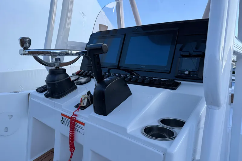 Slide: The Image of Control panel of 2022 Sea Hunt Ultra 234 boat with steering wheel and screens. - 9