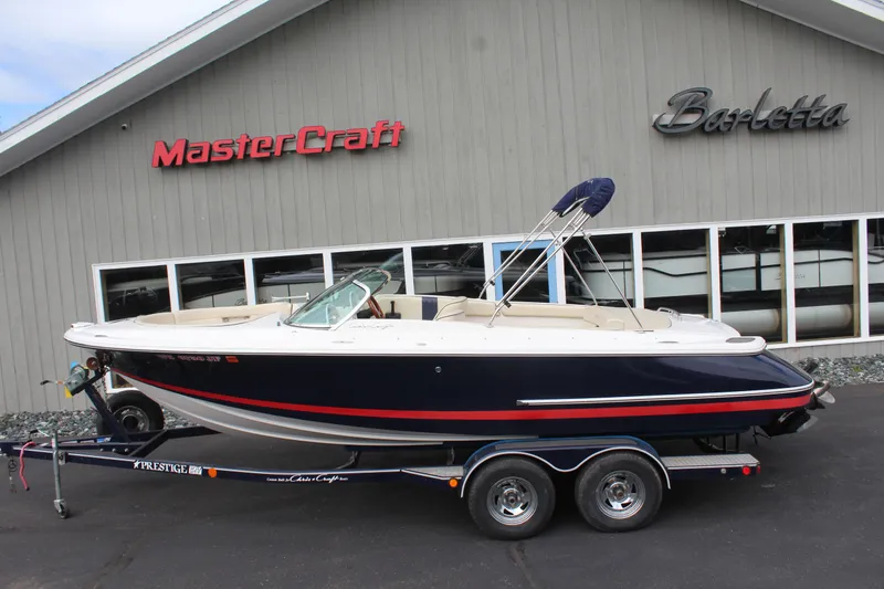 The Image of 2005 Chris-Craft Launch 22 boat on trailer in front of building. - 1