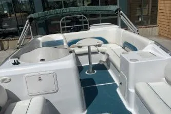 Slide: The Image of 2000 Hurricane FunDeck 198 RE boat interior with seating and table, featuring a canopy. - 12