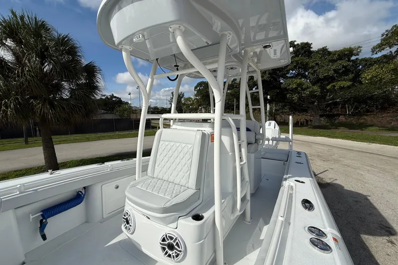 Slide: The Image of 2026 Yellowfin 26 Hybrid boat with seating and speakers, parked outdoors. - 12
