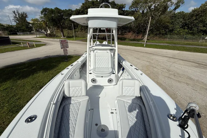 Slide: The Image of 2026 Yellowfin 26 Hybrid boat with sleek white interior and seating, parked on a sunny day. - 13