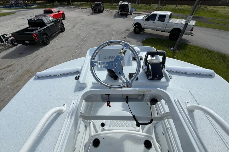 Slide: The Image of 2026 Yellowfin 26 Hybrid boat helm with Garmin navigation, parked trucks in background. - 16