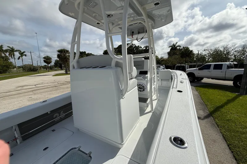 Slide: The Image of 2026 Yellowfin 26 Hybrid boat with sleek design, parked outdoors under cloudy sky. - 19
