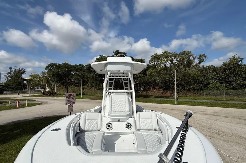 Slide: The Image of 2026 Yellowfin 26 Hybrid boat with sleek design, parked outdoors under a blue sky. - 21