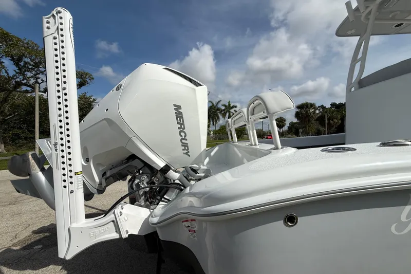 Slide: The Image of 2026 Yellowfin 26 Hybrid boat with Mercury engine, parked outdoors under a cloudy sky. - 22