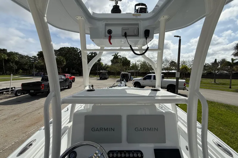 Slide: The Image of 2026 Yellowfin 26 Hybrid boat dashboard with Garmin displays, parked near trucks and greenery. - 25