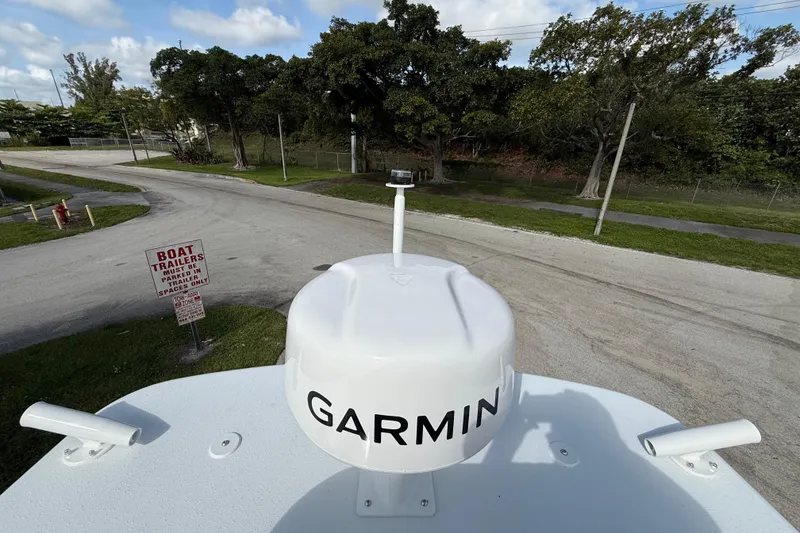 Slide: The Image of Top view of 2026 Yellowfin 26 Hybrid boat with Garmin radar, parked near trees. - 28