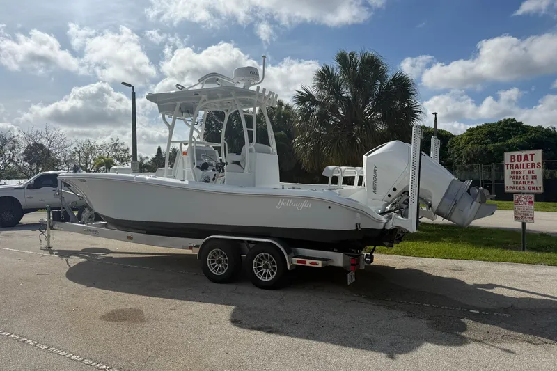 Slide: The Image of 2026 Yellowfin 26 Hybrid boat on trailer, parked outdoors under a cloudy sky. - 3