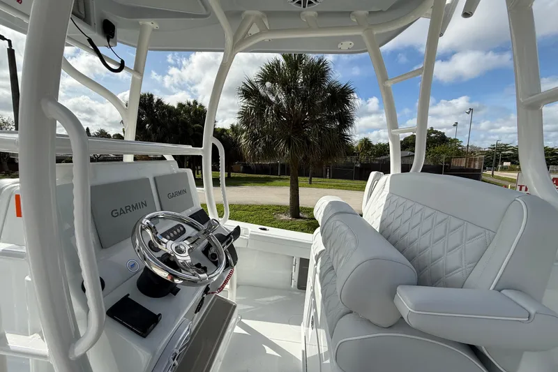 Slide: The Image of 2026 Yellowfin 26 Hybrid boat interior with Garmin navigation, white seating, and palm tree view. - 6