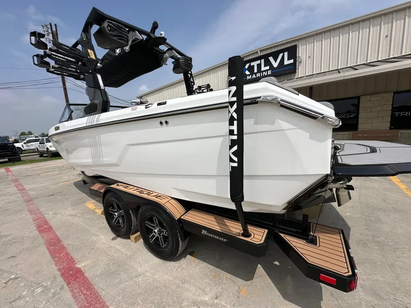 Slide: The Image of 2026 Nautique Super Air Nautique GS22 on trailer outside a building. - 3