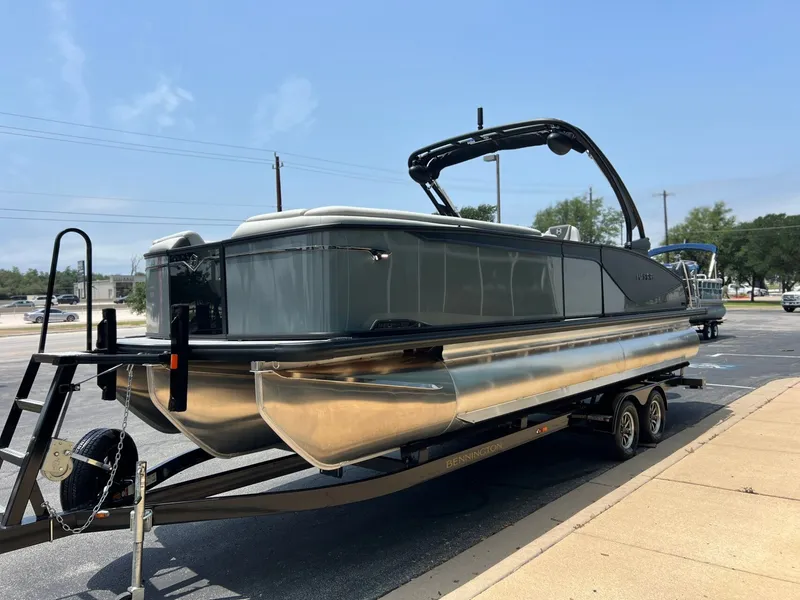 Slide: The Image of 2026 Harris Sunliner 250 pontoon boat parked on trailer. - 8