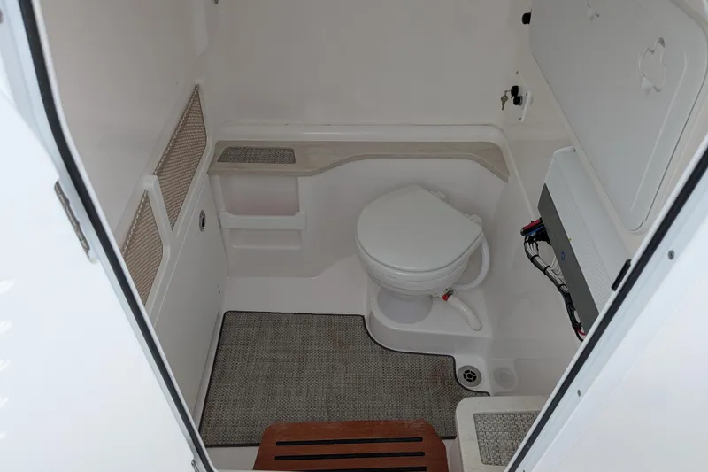 Slide: The Image of Interior of 2023 Everglades 273 Center Console boat featuring a compact marine toilet. - 10