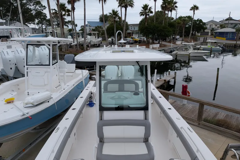 Slide: The Image of 2023 Everglades 273 Center Console boat docked at marina with palm trees. - 8
