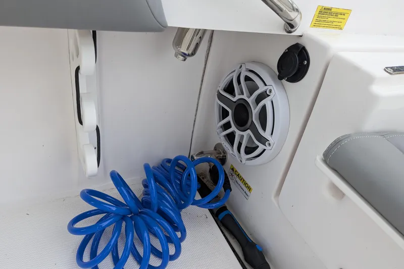 Slide: The Image of 2023 Everglades 273 Center Console boat interior with speaker and coiled blue hose. - 9