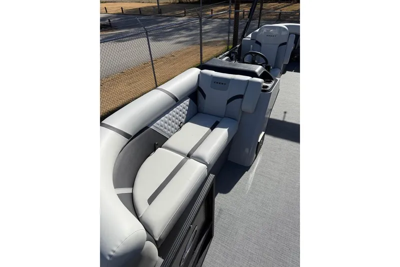 Slide: The Image of 2025 Crest CLASSIC 220 SLC boat interior with plush seating and steering console. - 7