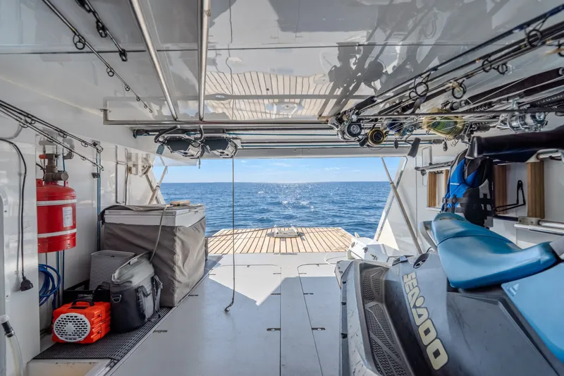 Slide: The Image of Interior view of 2004 Sunseeker 105 Yacht with ocean backdrop and watercraft storage. - 84
