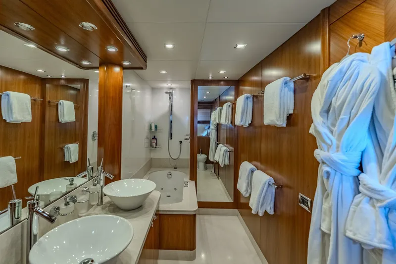 Slide: The Image of Luxurious bathroom on 2004 Sunseeker 105 Yacht with dual sinks, bathtub, and wooden accents. - 70