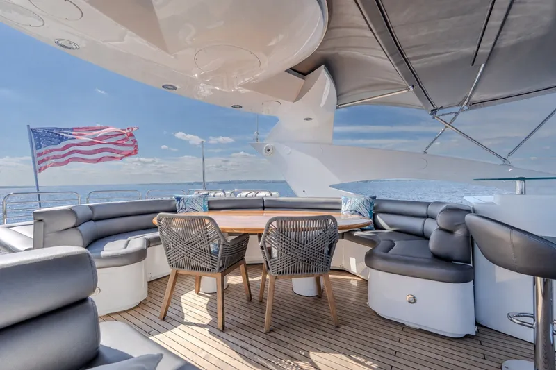 Slide: The Image of Luxurious 2004 Sunseeker 105 Yacht deck with seating, table, and American flag. - 24