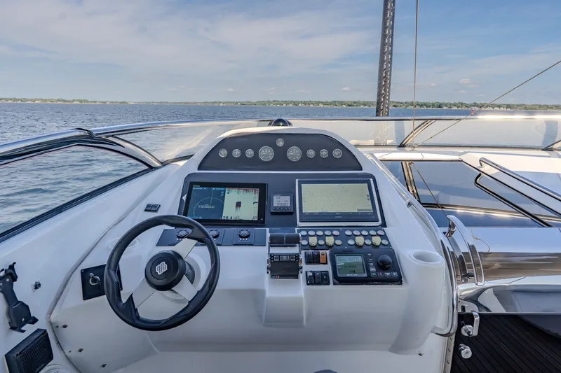 Slide: The Image of Cockpit view of 2004 Sunseeker 105 Yacht with navigation controls and ocean backdrop. - 26