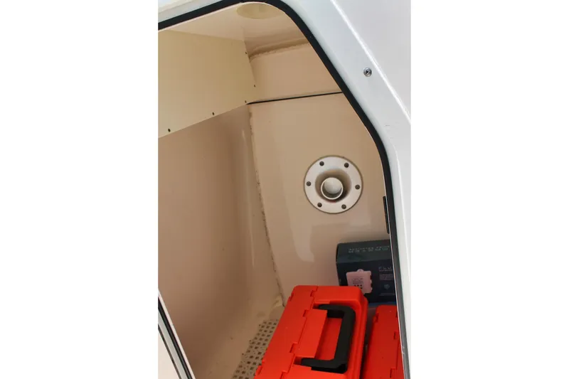 Slide: The Image of Interior storage compartment of 2018 Pursuit DC 265 Dual Console boat with orange toolbox. - 13