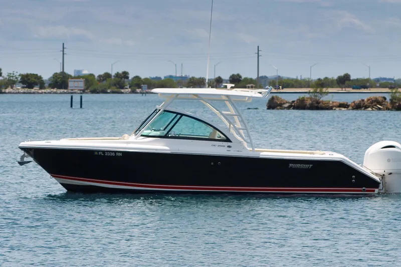 Slide: The Image of 2018 Pursuit DC 265 Dual Console boat on calm water, side view. - 15