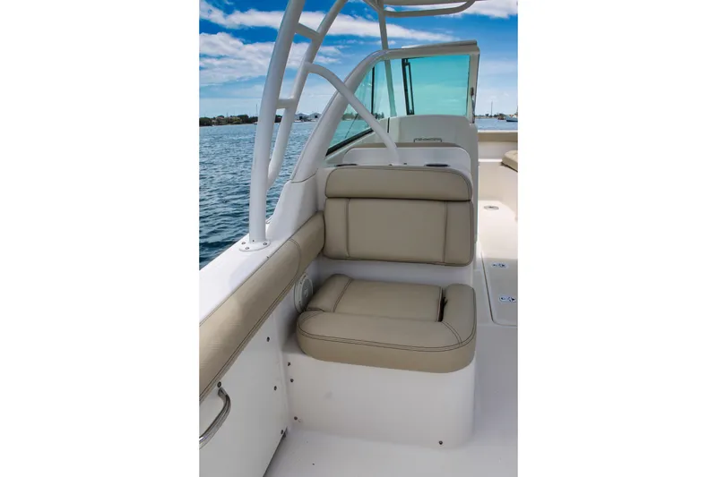 Slide: The Image of 2018 Pursuit DC 265 Dual Console boat interior with beige seating, ocean view, and blue sky. - 17