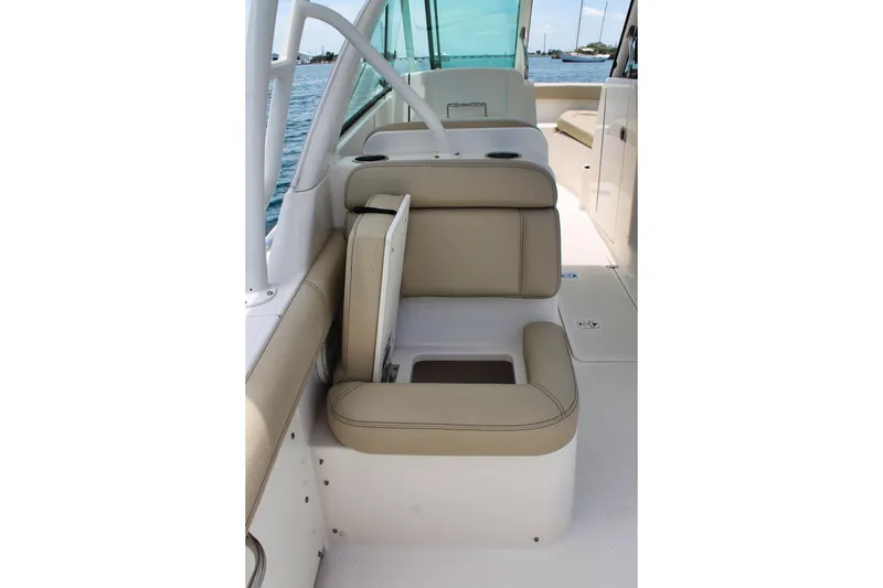 Slide: The Image of 2018 Pursuit DC 265 Dual Console boat interior with beige seating and cup holders. - 18